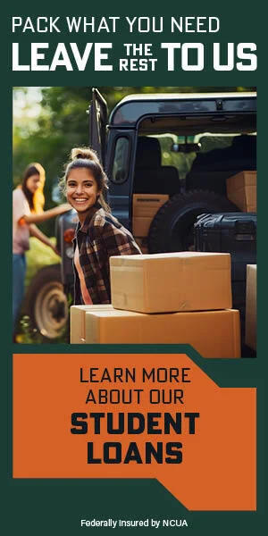 Smiling college girl loading boxes into back of vehicle
