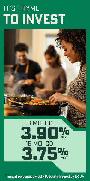Smiling African American woman cooking on stove with friends in the background