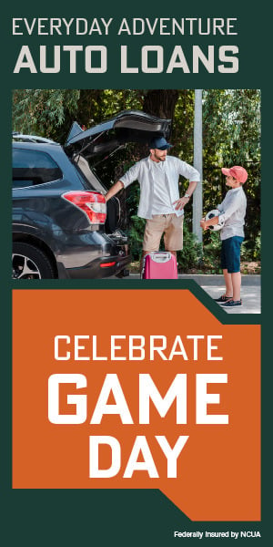 Father and son loading luggage into a new car before a family vacation.