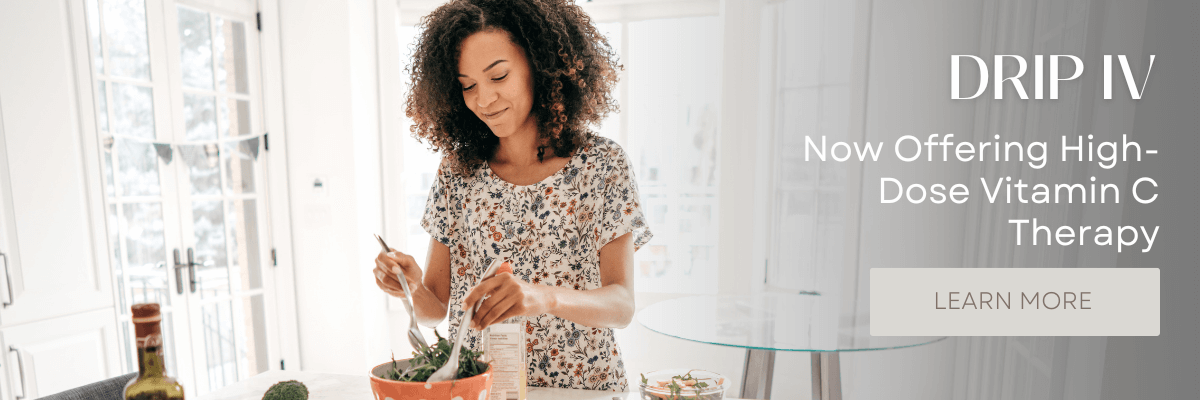 A woman making a salad in her kitchen promoting total wellness.
